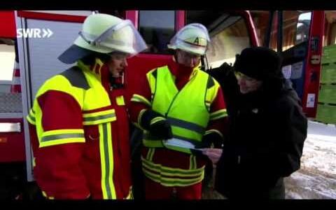 Screenshot: 2 Feuerwehrmänner erklären einer Reporterin das Informationsblatt zur Photovoltaik Anlage